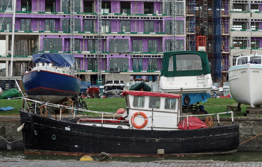 Boat in the Albert Basin marina with building work behind.
